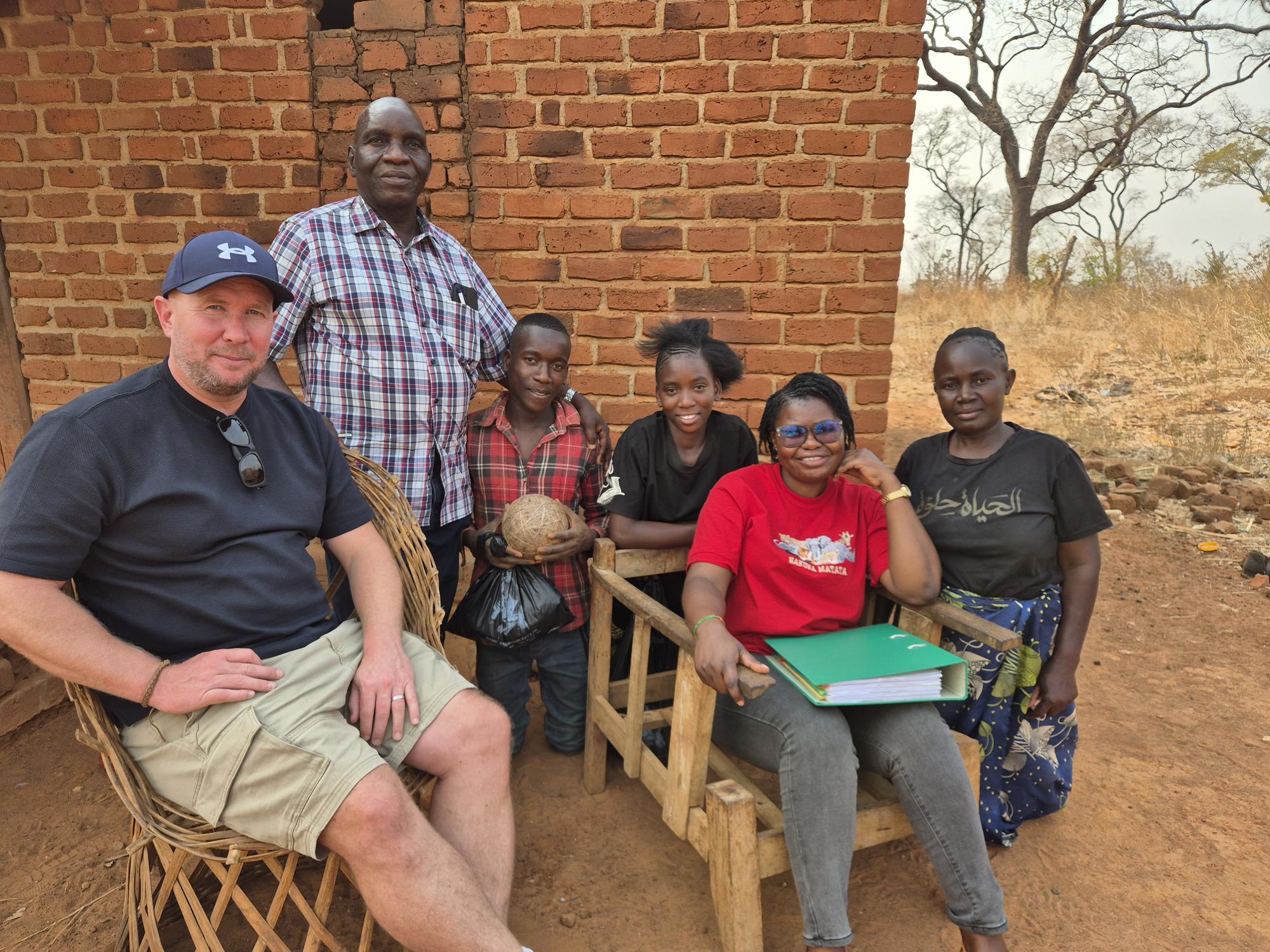 The ZOE team visiting a family and reviewing a child's progress at school.